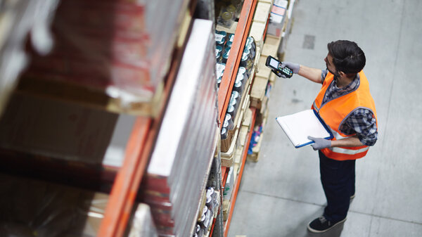 Arbeiter mit Scanner bei der Überprüfung von Waren im Lager