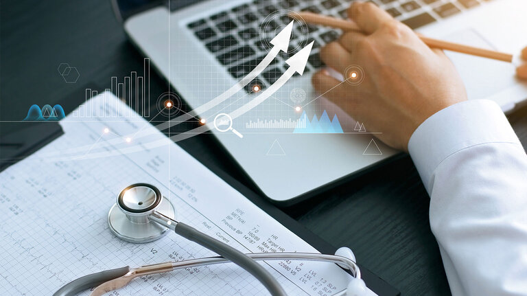 Stethoskop auf medizinischen Berichten neben einem Laptop, ergänzt durch digitale Diagramme und Pfeile, die Datenanalyse und Fortschritt in der Gesundheitsbranche darstellen.