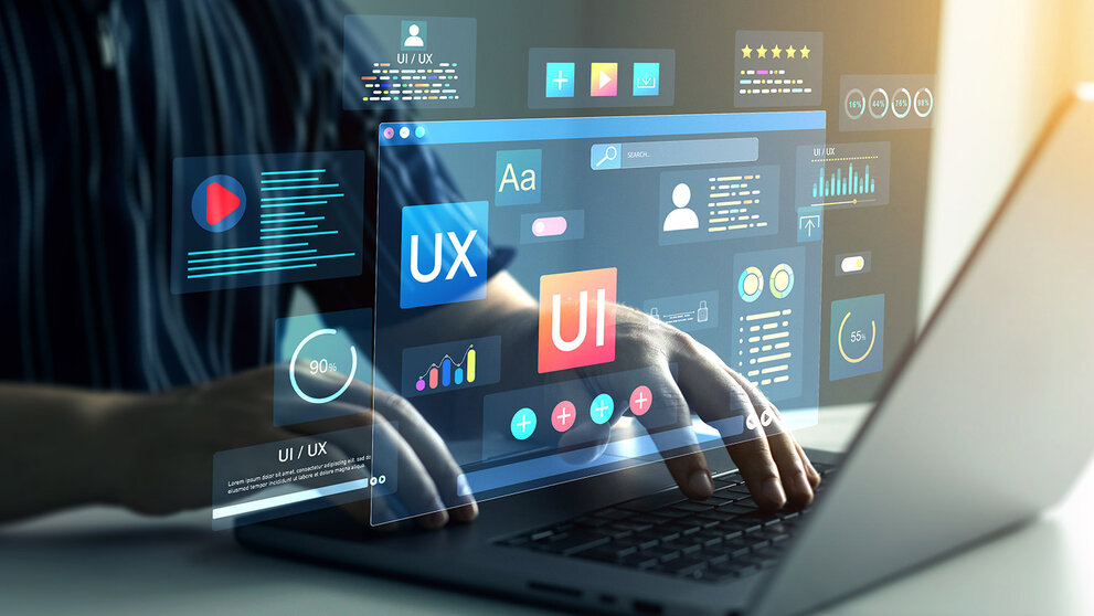 Person arbeitet am Laptop mit eingeblendeten UX- und UI-Elementen auf dem Bildschirm