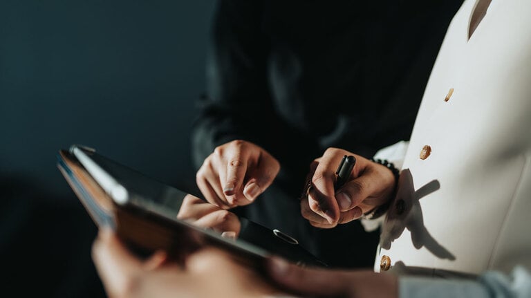Nahaufnahme von Händen von Geschäftsleuten, die mithilfe eines digitalen Tablets zusammenarbeiten und Strategien besprechen. Teamarbeit und Technologie steigern ihre Produktivität in einer modernen Büroumgebung.