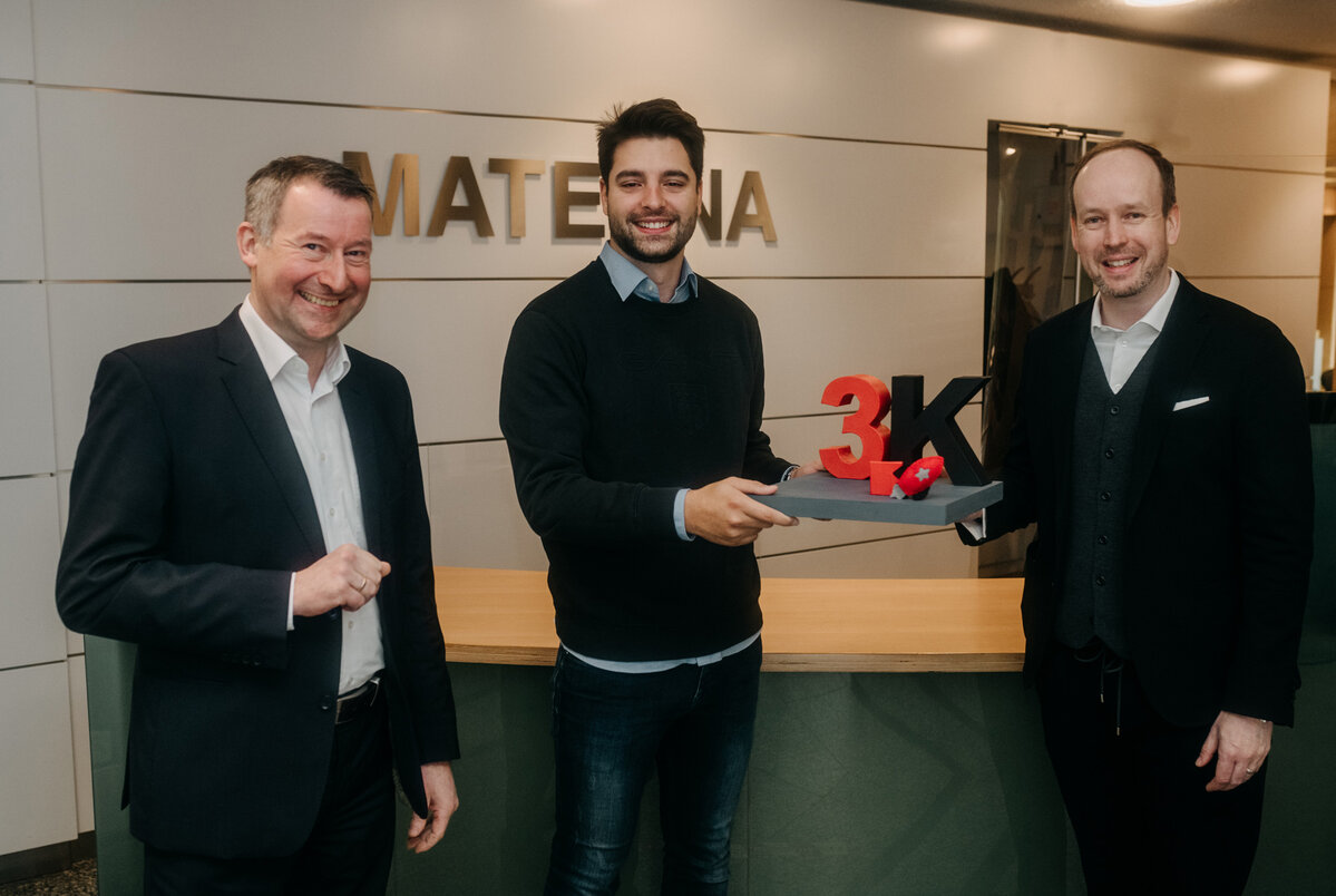 Gruppenfoto vor Materna-Logo zur Auszeichnung des 3.000 Mitarbeiters