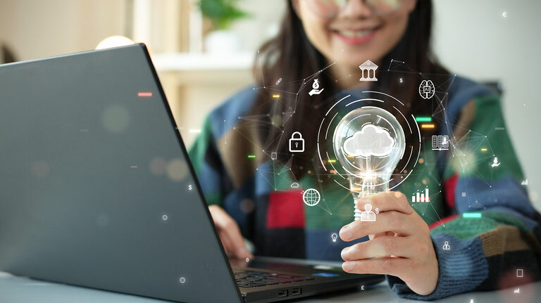 Frau hält eine Glühbirne mit Cloud-Symbol. Konzept der digitalen Technologie: Datenblattverwaltung mit großer Datenbankkapazität und hoher Sicherheit. Übergang der Datenspeicherung vom lokalen Computer zum Cloud-Computing.
