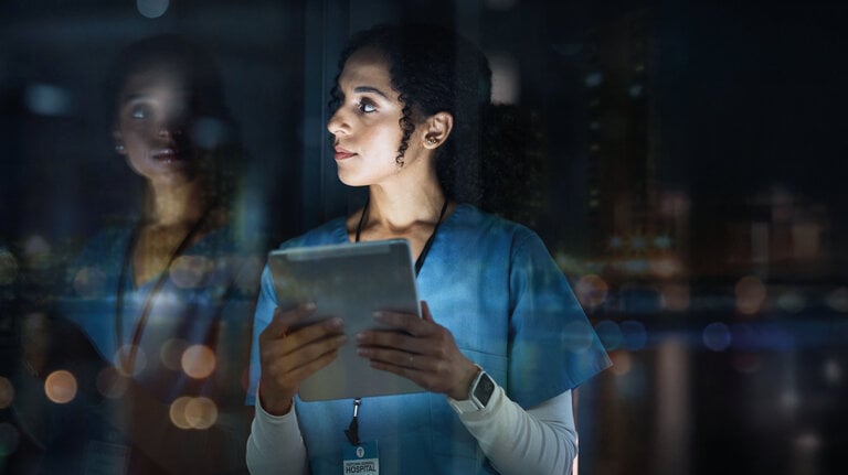 Medizin, Nachdenken und Nachtarbeit – eine Ärztin nutzt ein Tablet zur Planung, Medikamentenverwaltung und Terminorganisation.