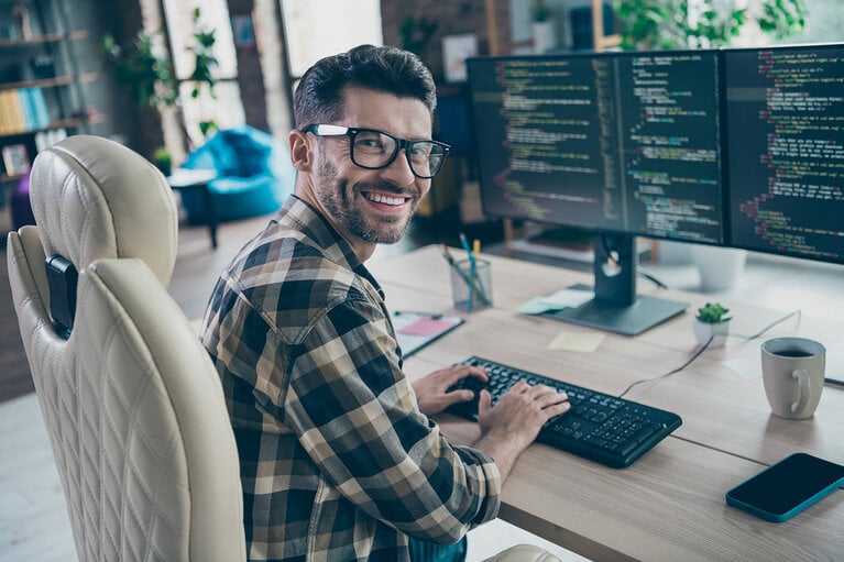 Profilbild eines freundlichen Hardware-Experten, der auf einem Stuhl sitzt und auf einer Tastatur tippt, um einen Code zu erstellen