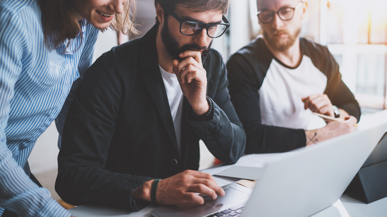 Ein Projektteam beim gemeinsamen Brainstorming im Meetingraum – Zusammenarbeit im Büro. Querformat mit unscharfem Hintergrund.
