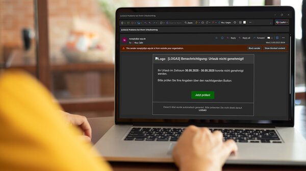 Frau liest am Laptop eine Phishing-Mail