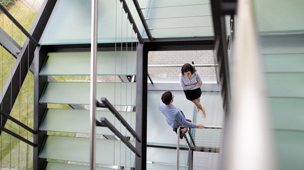 Junge Geschäftsleute steigen im Büro die Treppe hinauf 