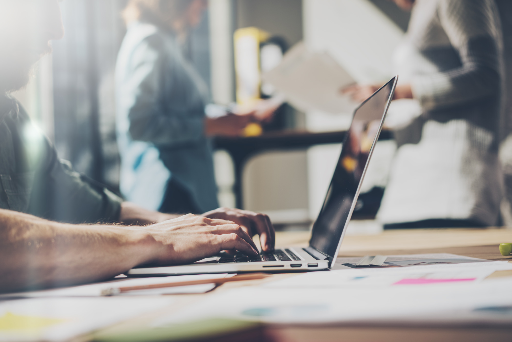 Mann arbeitet mit Laptop an Meeting-Tisch