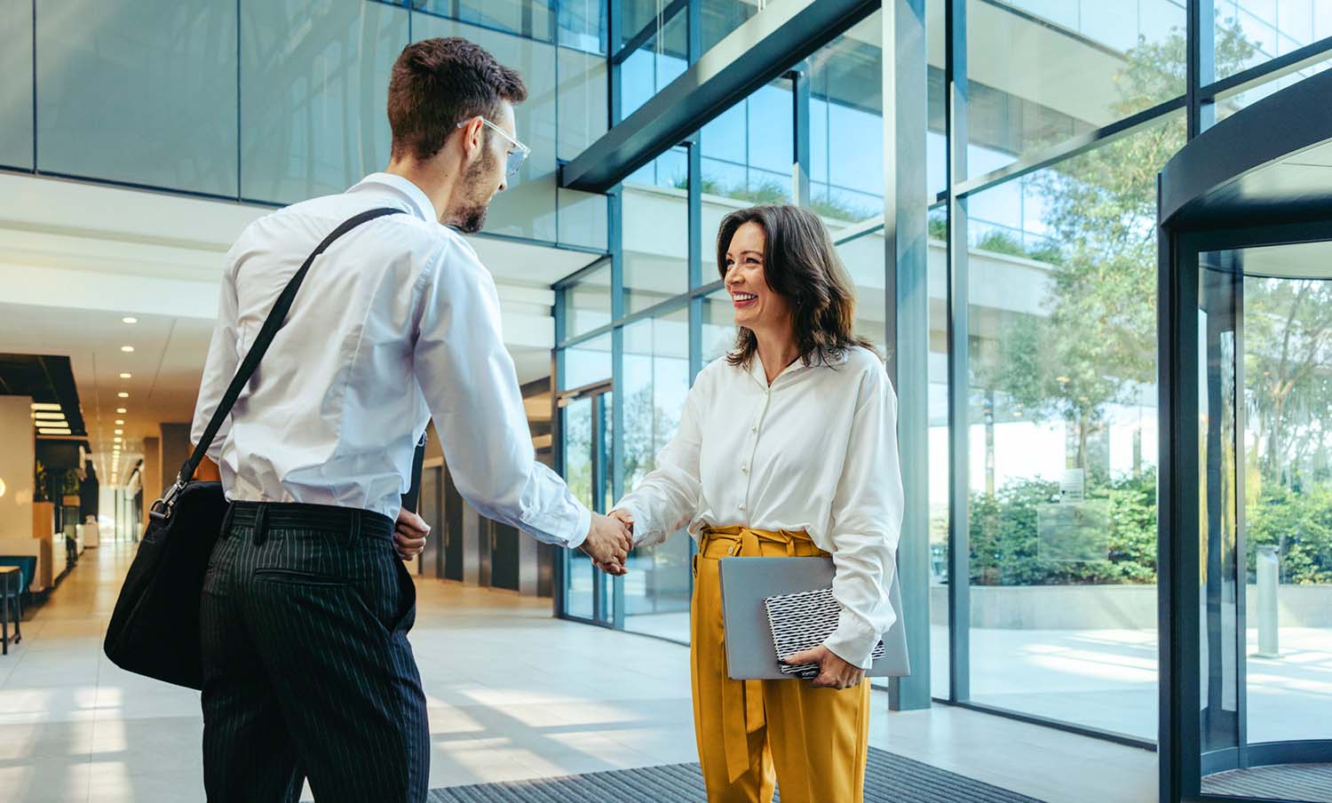 Berufskollegen treffen sich in der Lobby eines modernen Bürogebäudes