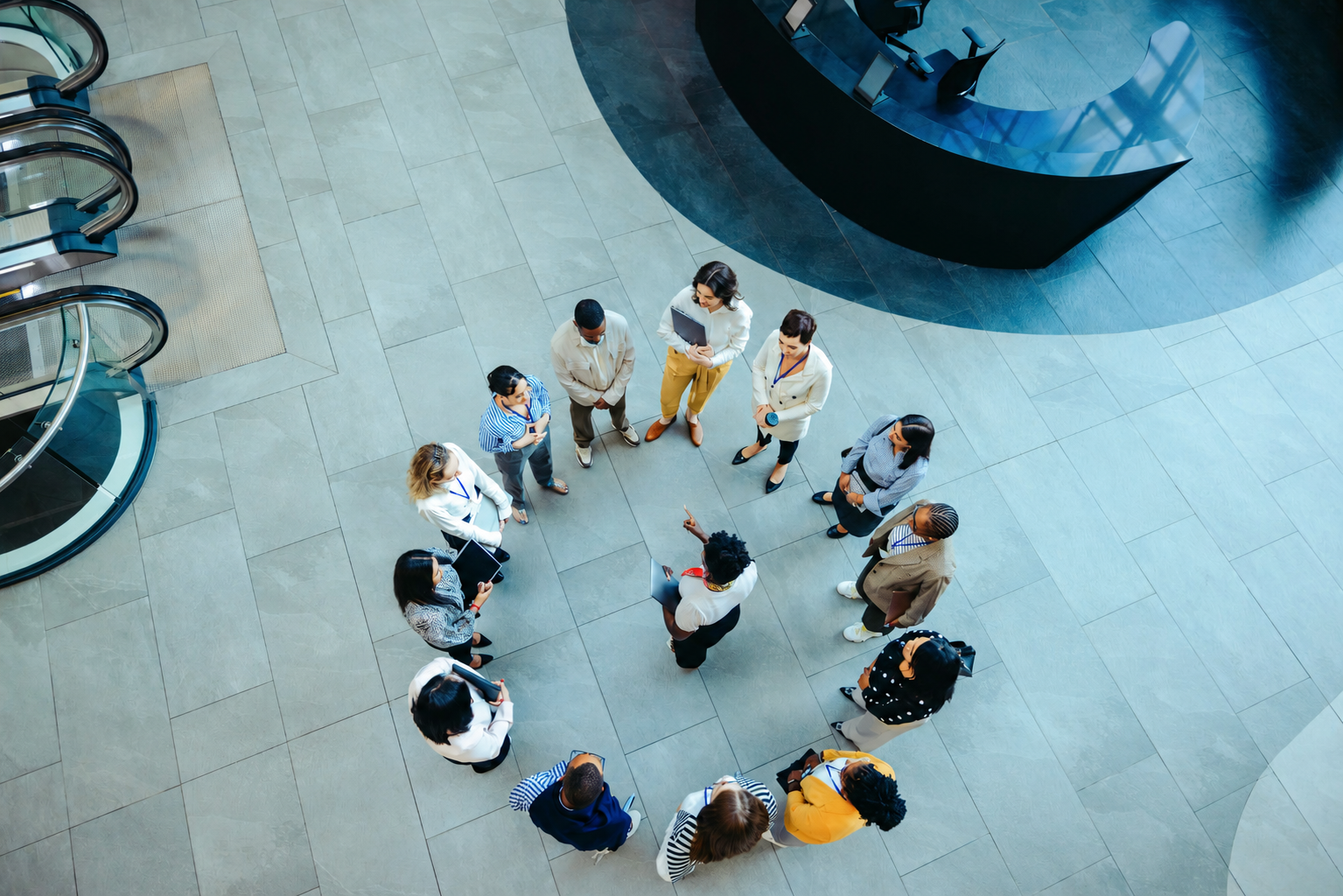 Das Team versammelt sich in einer kreisförmigen Formation in der Lobby eines modernen Bürogebäudes